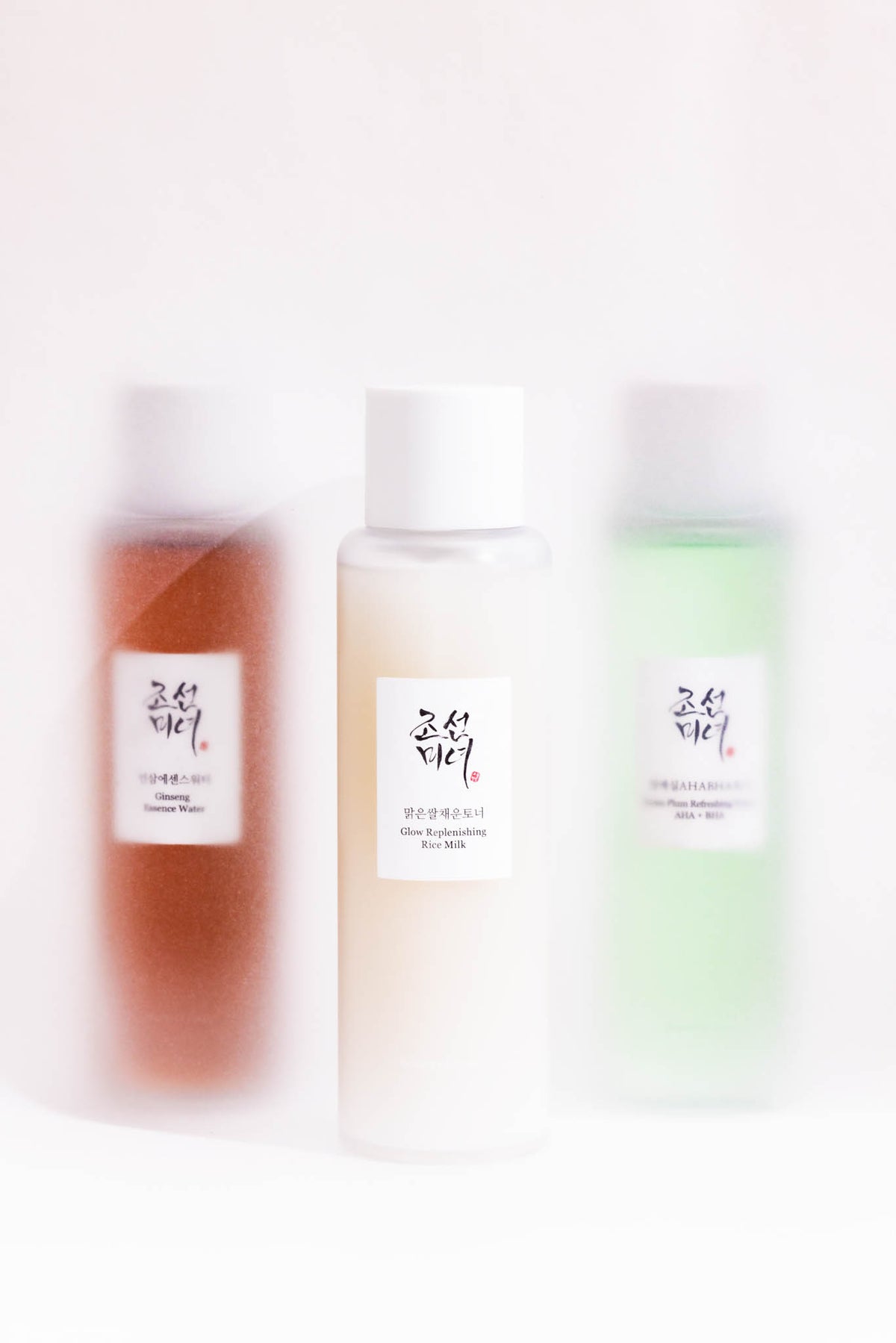 Essence au ginseng Ginseng Essence Water Beauty of Joseon, flacon flou à gauche de deux autres lotions de la marque