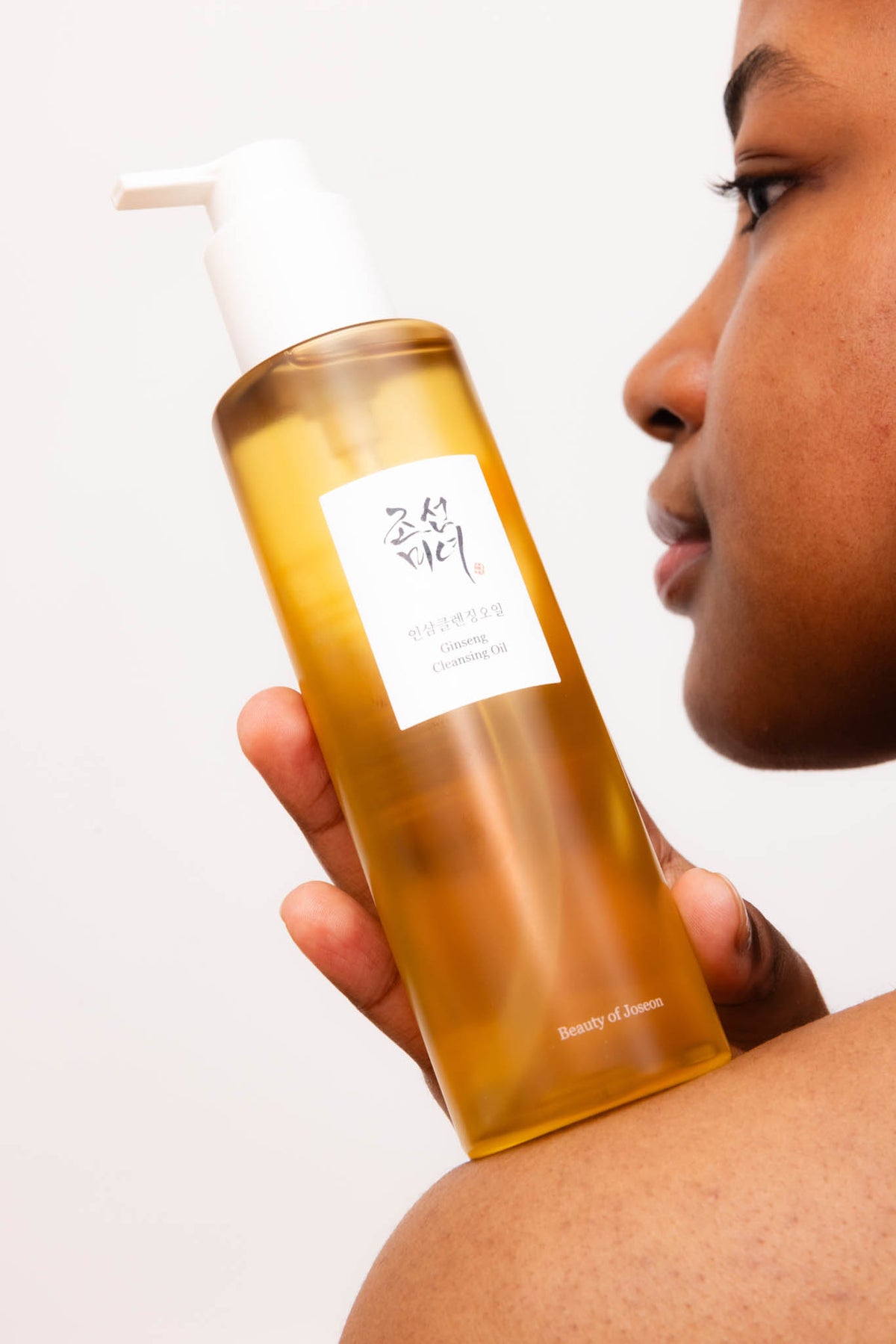 Huile démaquillante au ginseng Beauty of Joseon, flacon tenu contre l’épaule d’une mannequin de profil
