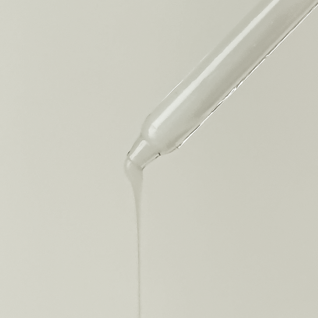 Ampoule réparatrice au lait d’ânesse DKMEX Dear Ohneul, pipette laissant couler la texture lactée, fond clair