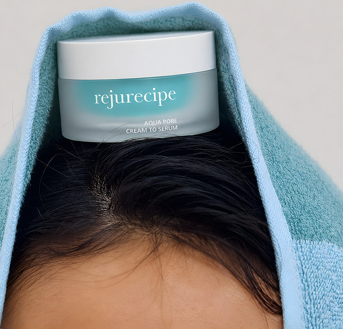 Le pot Rejurecipe Aqua Pore Cream to Serum de PESTLO posé sur la tête, sous une serviette