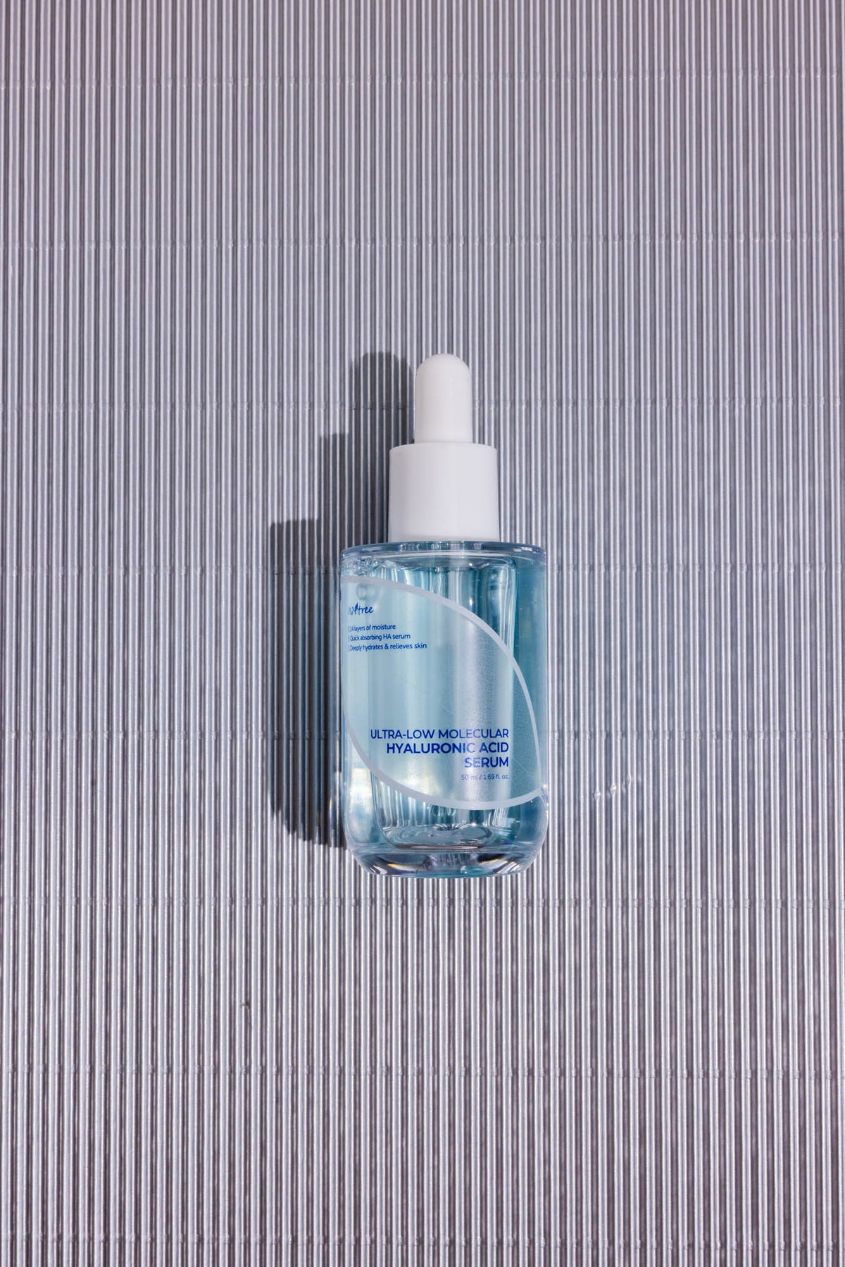 Sérum hydratant Ultra-Low Molecular Hyaluronic Acid Isntree, flacon compte-gouttes sur fond gris strié