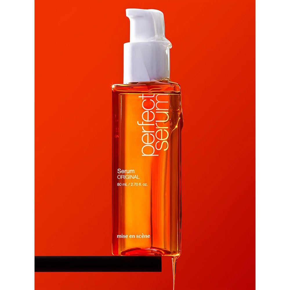 Sérum cheveux réparateur Perfect Serum Mise en Scène, flacon pompe orange sur fond rouge