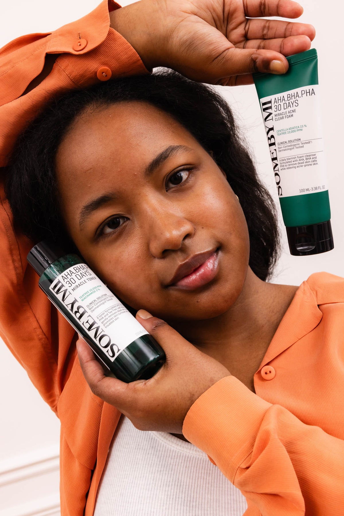 Mousse nettoyante AHA BHA PHA 30 Days Miracle SOME BY MI, mannequin tenant le tube et le tonique de la gamme