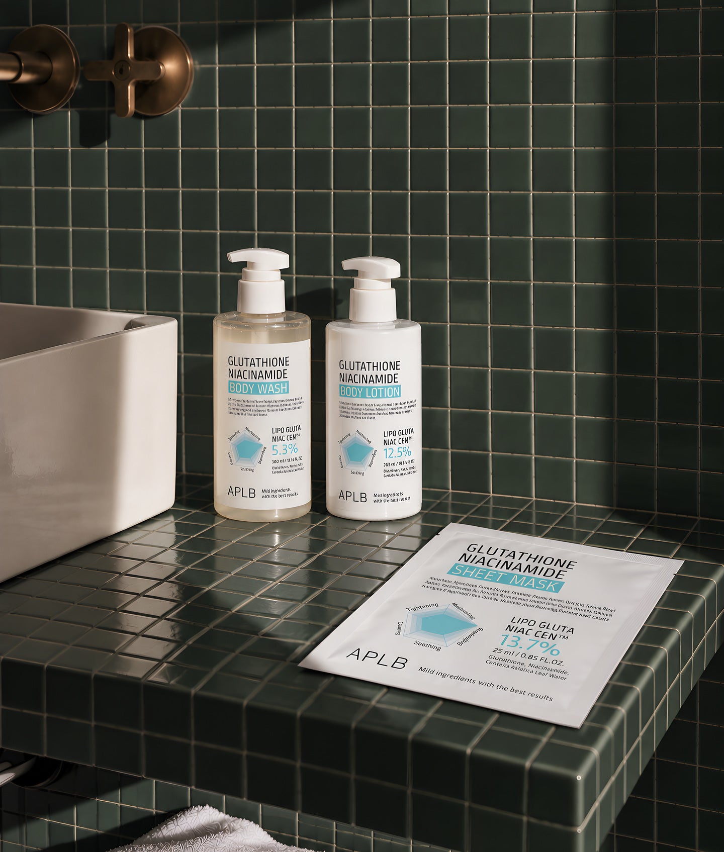 APLB, deux flacons pompe et un sachet Glutathione Niacinamide sur un rebord carrelé vert sombre