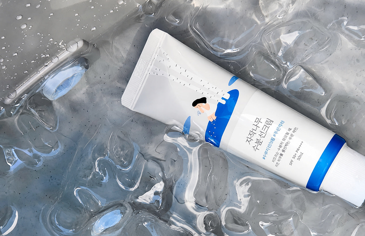 Round Lab, tube blanc et bleu de la marque posé dans une eau claire